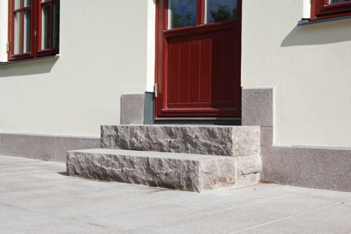 Liten trappa och hus-sockel i röd granit.